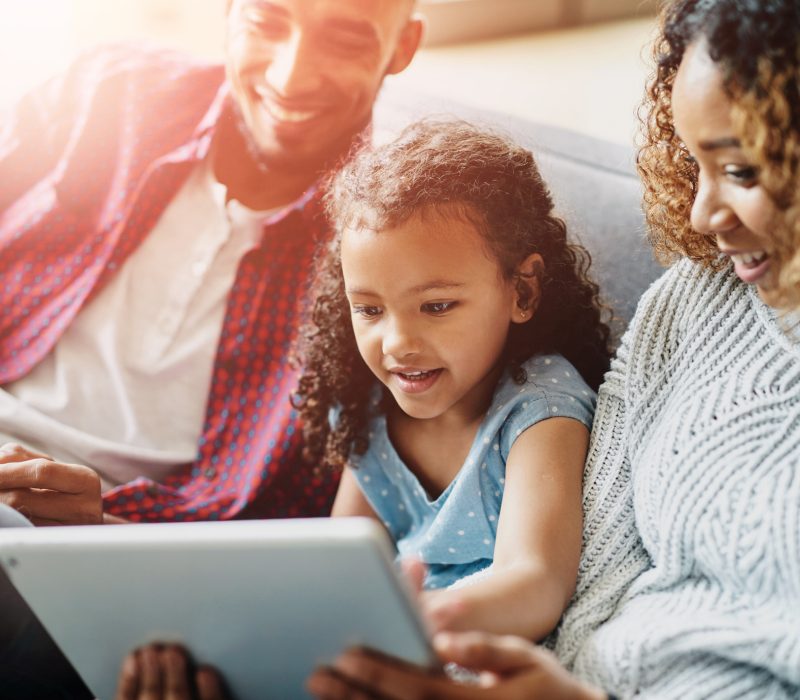 Family, living room or child with tablet for learning, growth and development with online game. Man, woman and girl with ebook in home for education, together on sofa with tech for multimedia website She's already a pro in handling technology